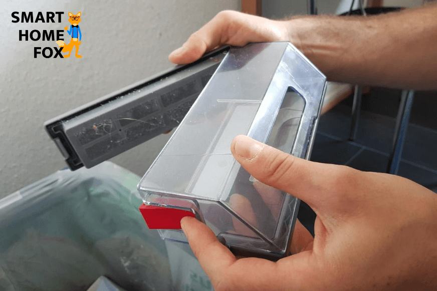 Der mobile Schmutzbehälter wird über einem Mülleimer ausgeleert